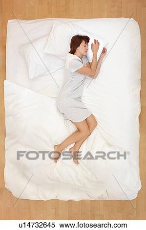Stock Photography - Woman lying in bed, asleep. Fotosearch