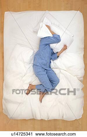 Woman lying in bed with pillow over head View Large Photo Image Stock Image - Woman lying in bed with pillow over head. Fotosearch