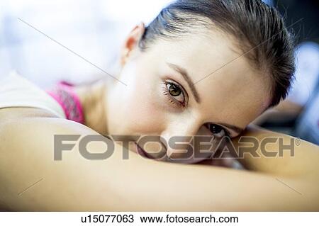 Stock Image - Woman resting on exercise machine. Fotosearch