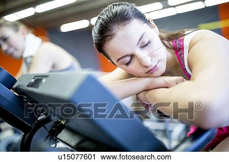 Woman resting on exercise machine View Large Photo Image Stock Image - Woman resting on exercise machine. Fotosearch