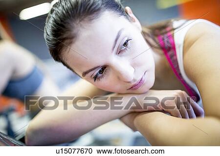 Woman resting on exercise machine View Large Photo Image Stock Image - Woman resting on exercise machine. Fotosearch