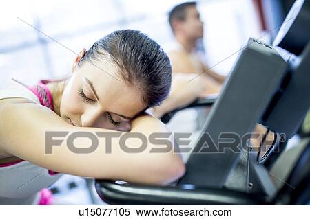 Woman resting on exercise machine View Large Photo Image Stock Photography - Woman resting on exercise machine. Fotosearch