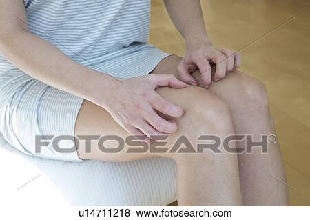 Woman scratching her legs View Large Photo Image Stock Photo - Woman scratching her legs. Fotosearch