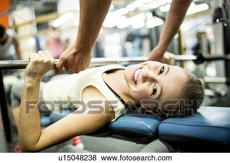 Stock Photo - Woman using exercise machine. Fotosearch