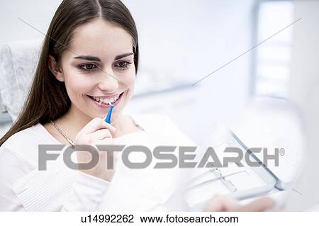 Stock Image - Woman using interdental brush. Fotosearch