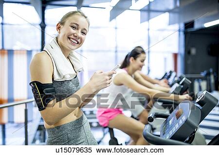 Woman using phone in gym View Large Photo Image Stock Photography - Woman using phone in gym. Fotosearch