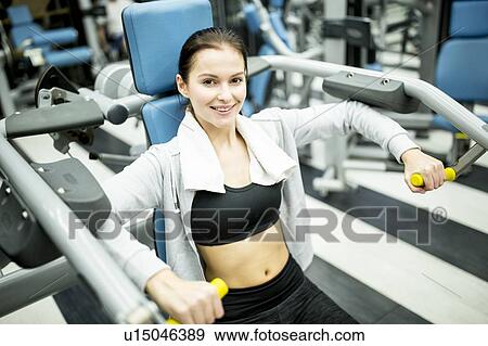 Woman using shoulder press machine View Large Photo Image Stock Photo - Woman using shoulder press machine. Fotosearch