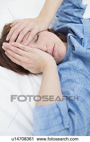 Stock Image - Woman with hands covering face. Fotosearch