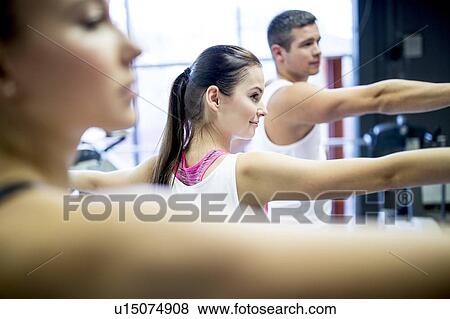 Stock Photo - Young adults doing warm up exercise. Fotosearch