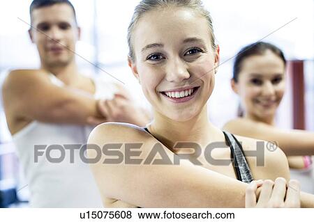 Stock Photo - Young adults doing warm up exercise. Fotosearch