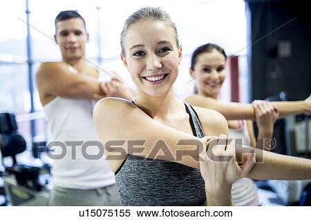 Stock Photography - Young adults doing warm up exercise. Fotosearch