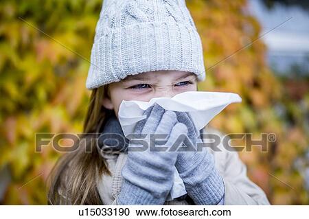 Stock Image - Young girl sneezing. Fotosearch