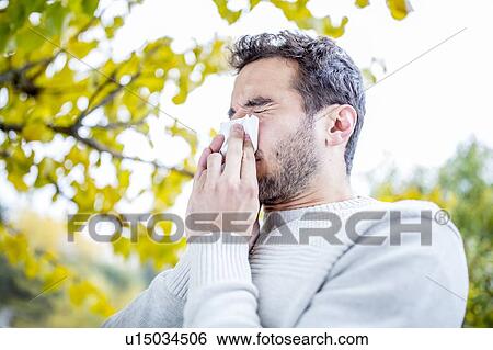 Young man sneezing View Large Photo Image Stock Photograph - Young man sneezing. Fotosearch