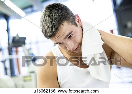 Young man wiping his sweat with towel View Large Photo Image Stock Photograph - Young man wiping his sweat with towel. Fotosearch