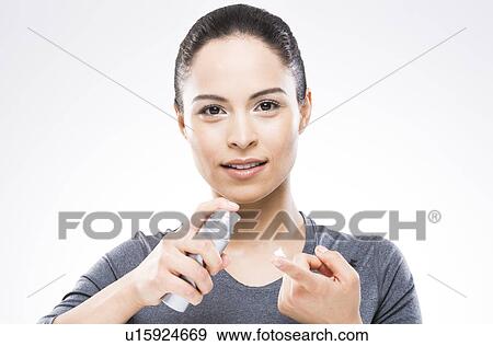 Young woman applying moisturizer View Large Photo Image Stock Photo - Young woman applying moisturizer. Fotosearch