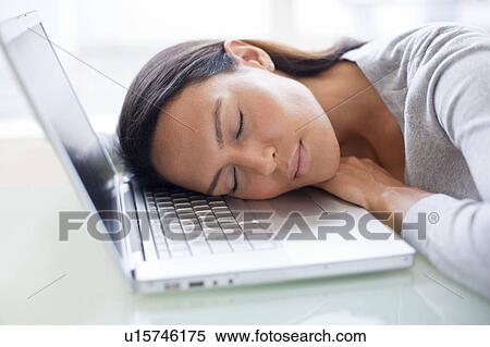 Stock Photography - Young woman asleep on laptop. Fotosearch