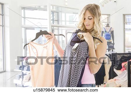 Young woman choosing clothing in boutique View Large Photo Image Stock Photography - Young woman choosing clothing in boutique. Fotosearch