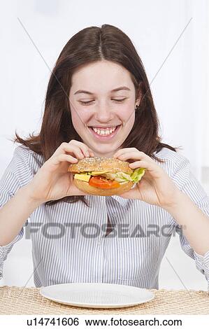 Stock Photograph - Young woman eating healthy sandwich. Fotosearch
