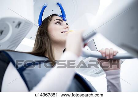Stock Image - Young woman having dental x-ray. Fotosearch