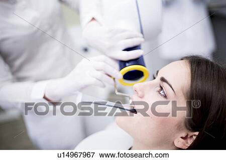 Stock Photo - Young woman having dental x-ray. Fotosearch