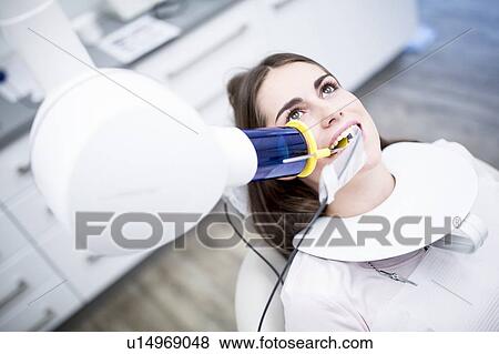 Stock Photo - Young woman having dental x-ray. Fotosearch