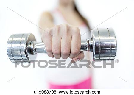 Young woman holding dumbbell, close-up View Large Photo Image Stock Photo - Young woman holding dumbbell, close-up. Fotosearch