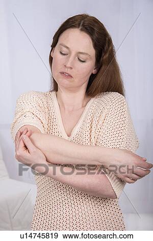 Stock Photo - Young woman holding her elbow. Fotosearch
