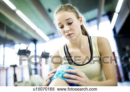 Young woman holding ice pack on knee View Large Photo Image Stock Photography - Young woman holding ice pack on knee. Fotosearch
