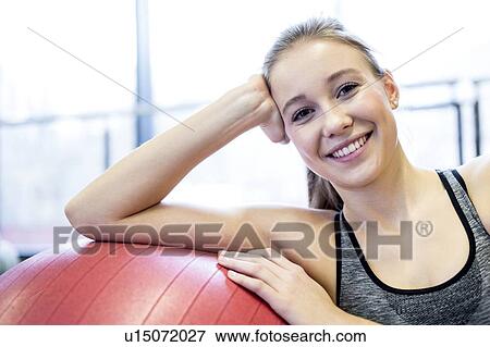 Young woman leaning on fitness ball View Large Photo Image Stock Photo - Young woman leaning on fitness ball. Fotosearch