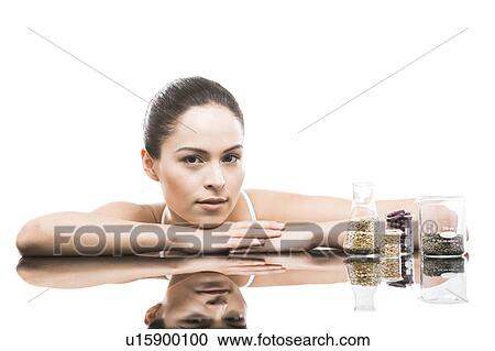 Stock Image - Young woman leaning on mirror. Fotosearch