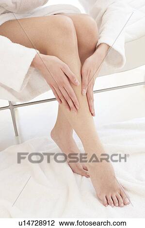 Young woman rubbing leg View Large Photo Image Stock Image - Young woman rubbing leg. Fotosearch