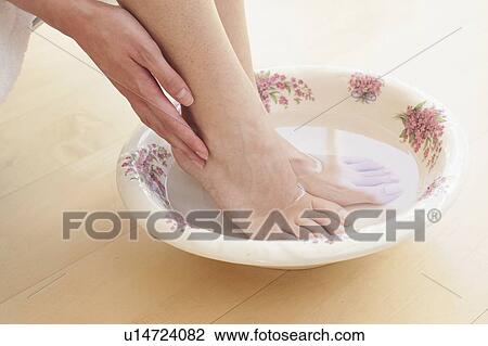 Young woman soaking feet in bowl of water View Large Photo Image Stock Image - Young woman soaking feet in bowl of water. Fotosearch