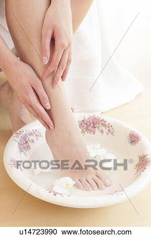 Young woman soaking foot in bowl of water View Large Photo Image Stock Image - Young woman soaking foot in bowl of water. Fotosearch