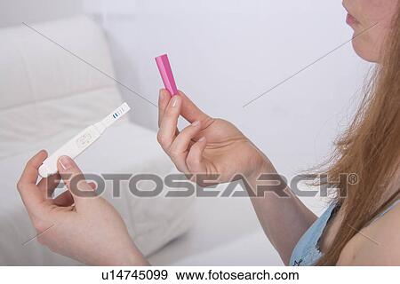 Stock Photo - Young woman taking pregnancy test at home. Fotosearch