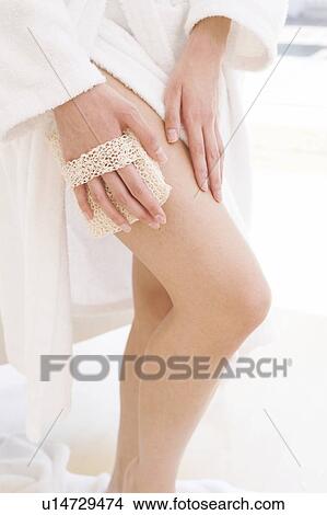 Young woman using exfoliator sponge View Large Photo Image Picture - Young woman using exfoliator sponge. Fotosearch