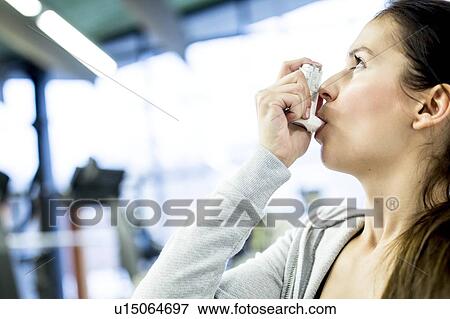 Stock Photo - Young woman using inhaler. Fotosearch