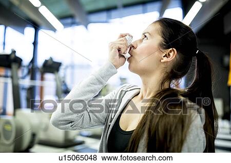Young woman using inhaler View Large Photo Image Stock Photo - Young woman using inhaler. Fotosearch