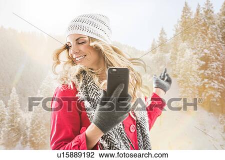 Young woman wearing winter clothing dancing with smart phone in hands View Large Photo Image Stock Image - Young woman wearing winter clothing dancing with smart phone in hands. Fotosearch