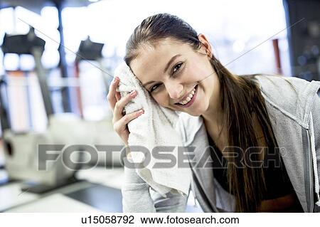 Young woman wiping her face View Large Photo Image Stock Image - Young woman wiping her face. Fotosearch