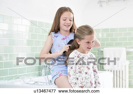 Big sister brushing little sister's hair View Large Photo Image Stock Photo - Big sister brushing little sister's hair. Fotosearch