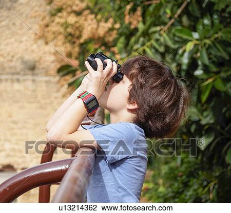 Stock Image - Boy of seven with a binocular. Fotosearch