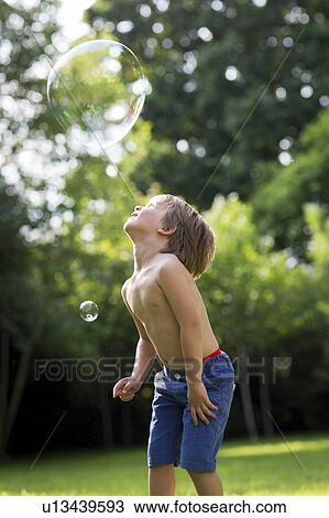 Stock Image - Boy watching bubble. Fotosearch