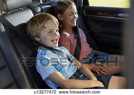 Stock Image - Brother and sister in car. Fotosearch