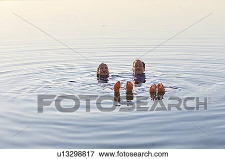 Couple floating in the sea View Large Photo Image Stock Photo - Couple floating in the sea. Fotosearch