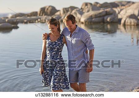 Stock Photograph - Couple paddling in the sea. Fotosearch