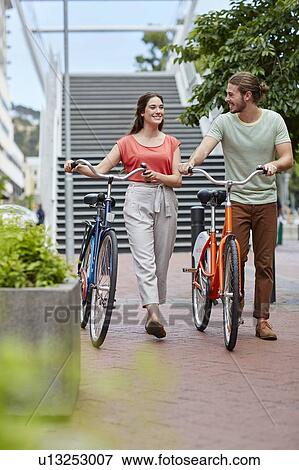 Couple walking with bikes View Large Photo Image Stock Photo - Couple walking with bikes. Fotosearch