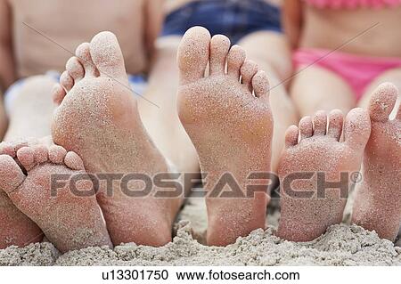 Stock Image - Family sitting on beach. Fotosearch