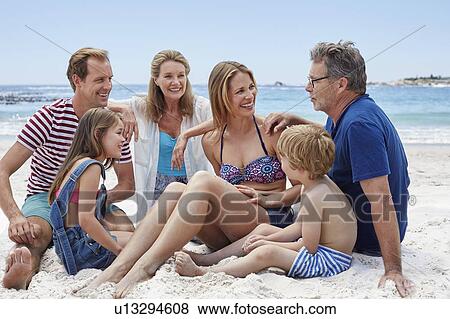 Family sitting on beach View Large Photo Image Stock Photo - Family sitting on beach. Fotosearch