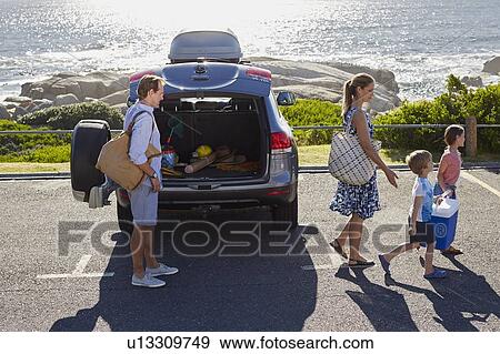Family unpacking the car by the beach View Large Photo Image Stock Photo - Family unpacking the car by the beach. Fotosearch