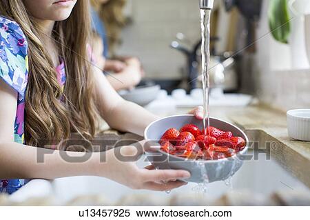 Stock Photography - Girl washing fresh strawberries. Fotosearch